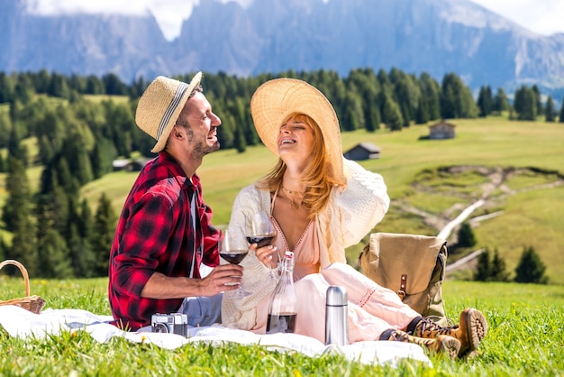 Pareja joven enamorada haciendo picnic visitando dolomías de los Alpes