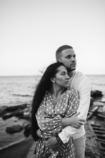 Pareja joven enamorada Hombre y mujer atractivos disfrutando de una velada romántica en la playa viendo la puesta de sol