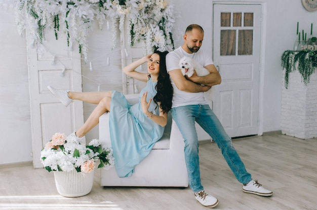 Pareja joven esperando a bebé de pie juntos en el interior