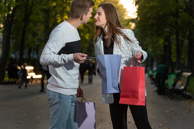 Pareja joven está discutiendo sobre compras después de comprar Chico y chica comparten bolsa de compras