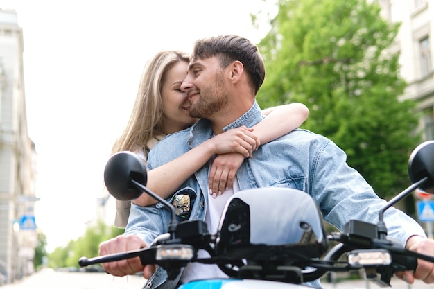 Pareja joven con estilo con una motocicleta en una calle de la ciudad