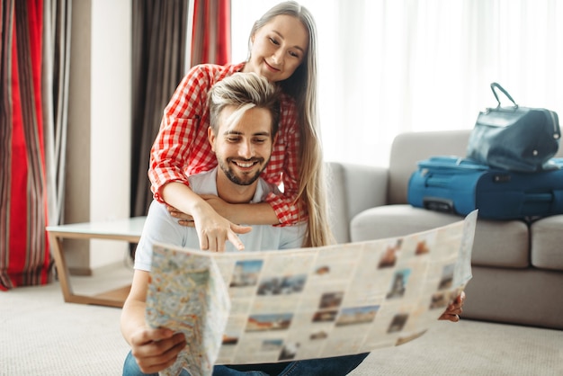 Pareja joven estudiando un mapa antes del viaje de verano