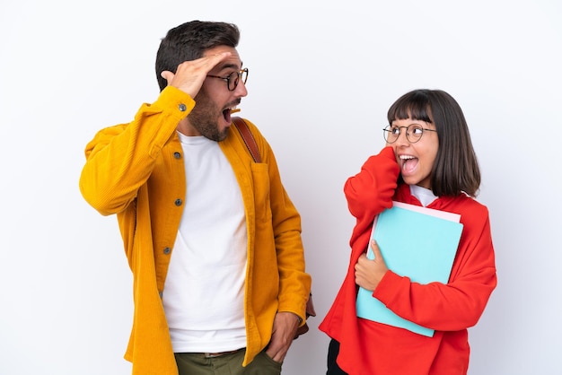 Pareja joven estudiante aislado sobre fondo blanco con sorpresa y expresión facial conmocionada