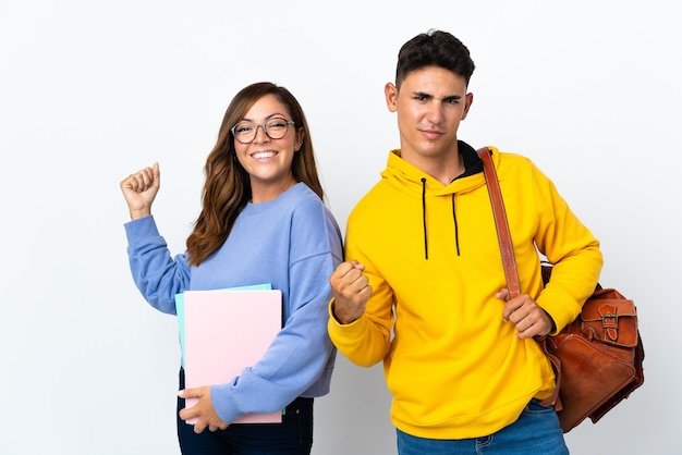 Pareja joven estudiante en blanco celebrando una victoria