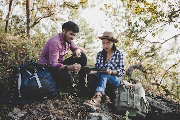 Pareja joven excursionistas con y buscando en el mapa para encontrar una manera