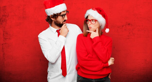 Pareja joven expresando el concepto de Navidad. Pareja y fondo en diferentes capas.