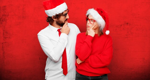 Pareja joven expresando el concepto de Navidad. Pareja y fondo en diferentes capas.