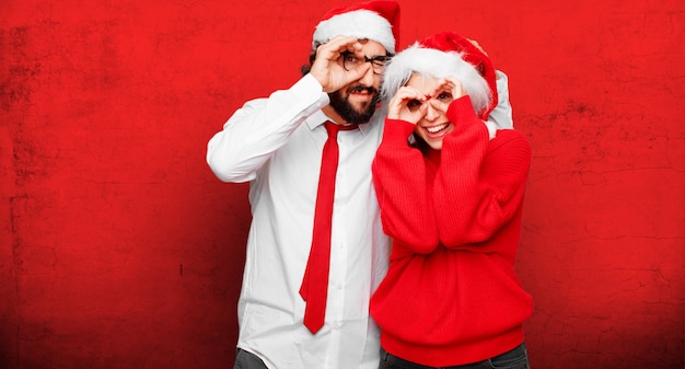 Pareja joven expresando el concepto de Navidad. Pareja y fondo en diferentes capas.