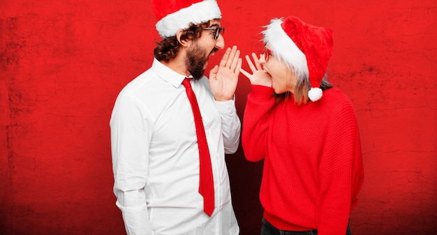 Pareja joven expresando el concepto de Navidad. Pareja y fondo en diferentes capas.