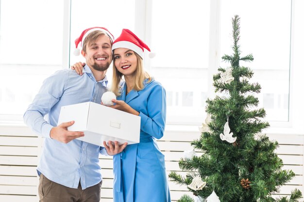 Pareja joven familia decorando el árbol de navidad