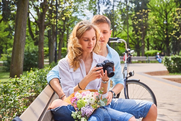 Pareja joven en la fecha usando una cámara de fotos SLR compacta.