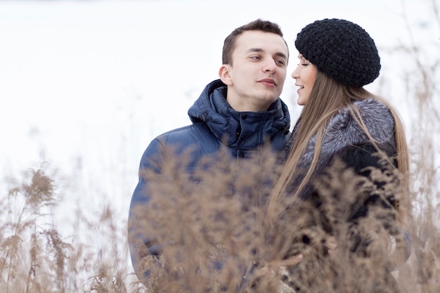 Pareja joven feliz en el campo de invierno