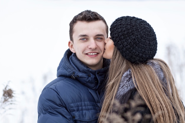 Pareja joven feliz en el campo de invierno