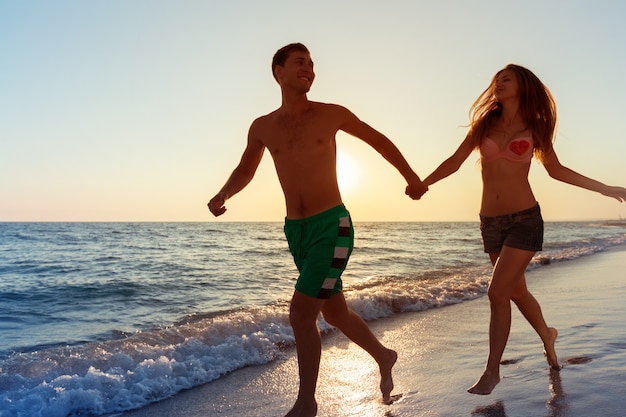 Pareja joven feliz disfrutando del mar