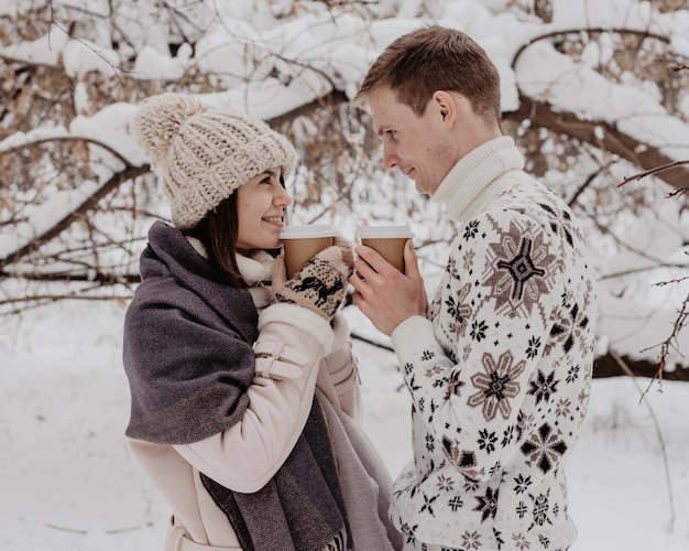 Pareja joven feliz en el parque de invierno divirtiéndose. Familia al aire libre. amor