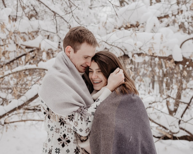 Pareja joven feliz en el parque de invierno divirtiéndose. Familia al aire libre. amor