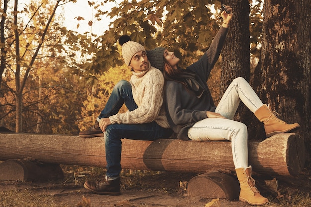 Pareja joven y feliz en el parque otoño