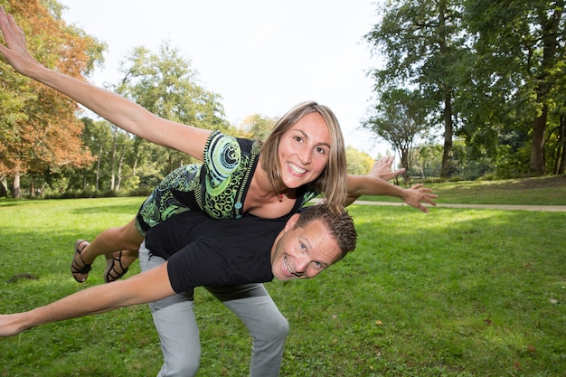 Pareja joven feliz riendo y diviértete en el parque de la ciudad