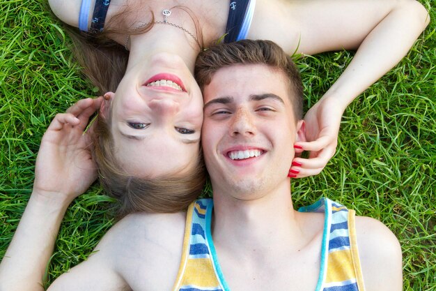 Una pareja joven y feliz tirada en un prado