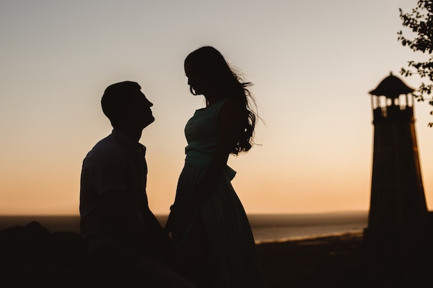 Pareja joven en el fondo de un faro en el mar