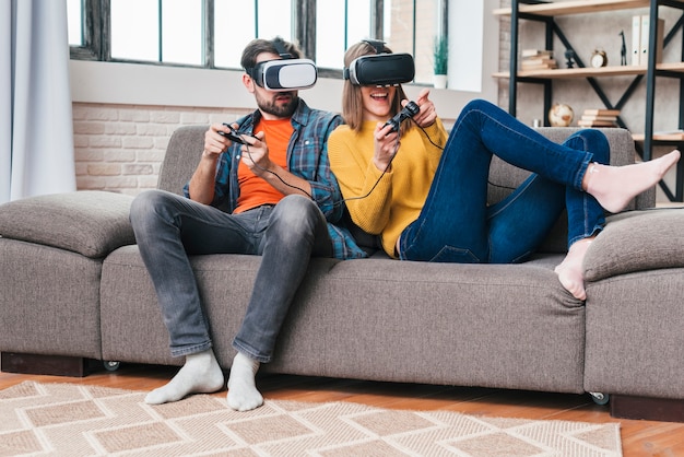 Foto pareja joven con gafas de realidad virtual jugando el videojuego