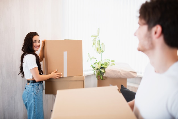 Pareja joven con gran caja de cartón en el nuevo hogar. Casa móvil.