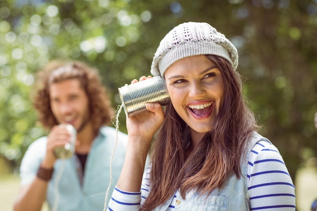 Foto pareja joven gritando a través de latas