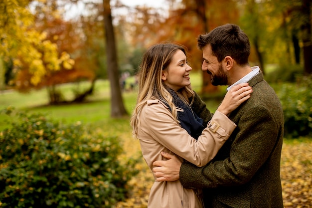 Pareja joven guapo caminando en el parque otoño