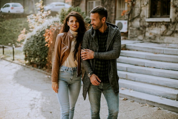 Pareja joven guapo caminando en el parque otoño