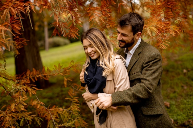 Pareja joven guapo en el parque otoño