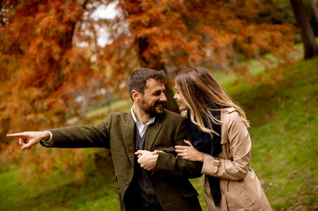 Pareja joven guapo en el parque otoño