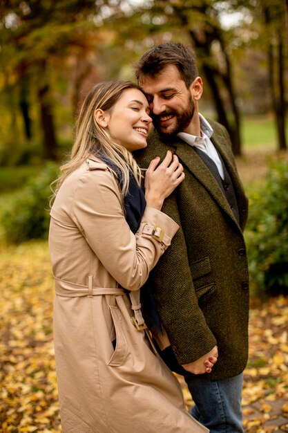 Pareja joven guapo en el parque otoño