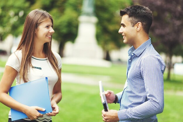 Foto una pareja joven hablando al aire libre.