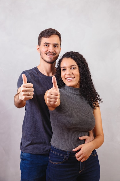 Pareja joven, hacer, ok, señal, en, pared gris