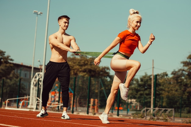 Pareja joven haciendo deporte con gomas deportivas