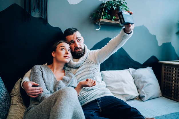 Pareja joven haciendo muecas y tomando selfie