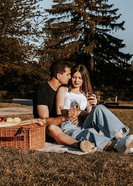 Foto una pareja joven haciendo un picnic en el parque.