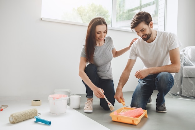 Pareja joven haciendo reparación de apartamentos juntos ellos mismos