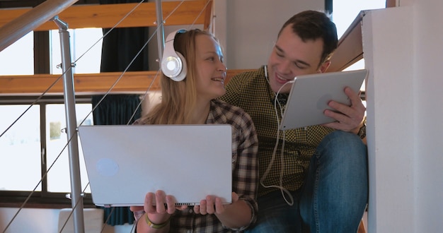 Foto pareja joven en heaphones en casa disfrutando de la música