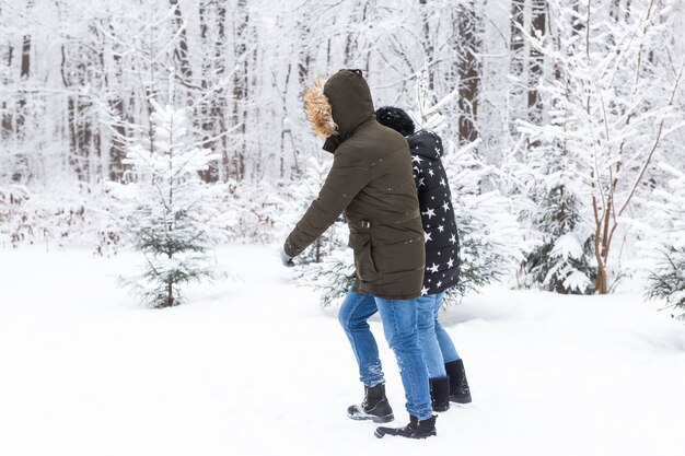 Una pareja joven y hermosa se divierte en el parque, corriendo y tomados de la mano. Concepto de historia de amor y el día de San Valentín. Temporada de invierno.