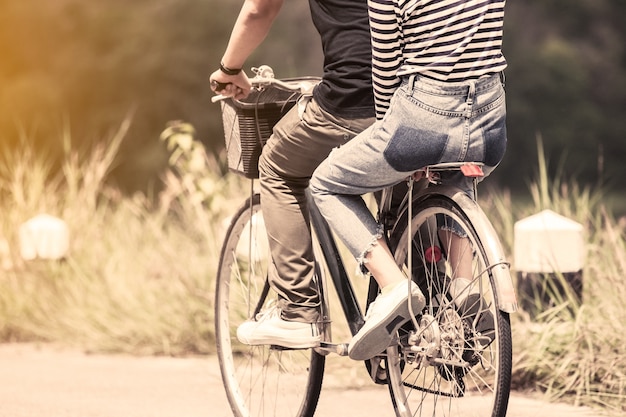 Pareja joven de hipsters montando una bicicleta