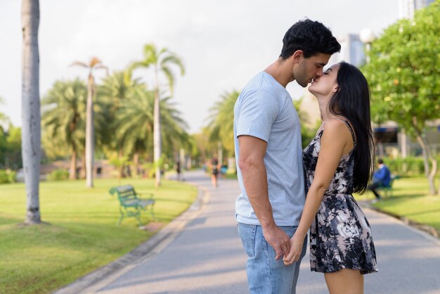 Pareja joven hispana relajante en el parque juntos