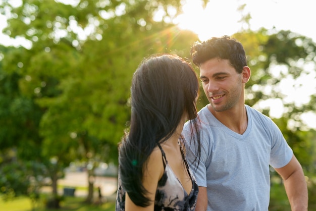 Pareja joven hispana relajante en el parque juntos