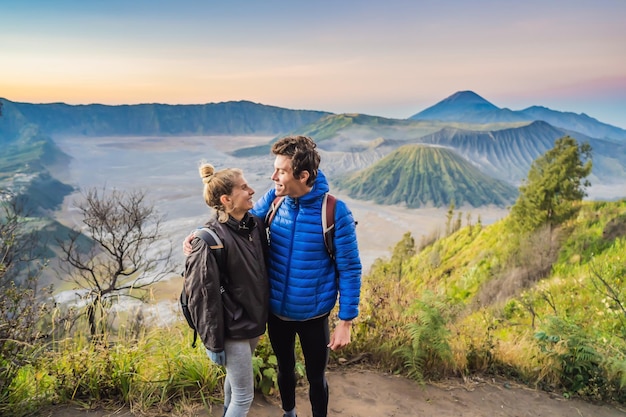 Pareja joven hombre y mujer se encuentran con el amanecer en el parque nacional bromo tengger semeru en java