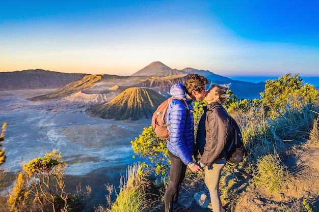 Pareja joven hombre y mujer se encuentran con el amanecer en el parque nacional bromo tengger semeru en java