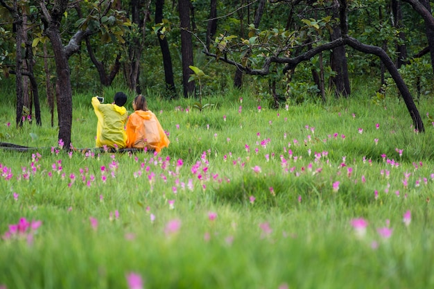 Pareja joven hombre y mujer haciendo selfie en el campo de flores de color rosa.