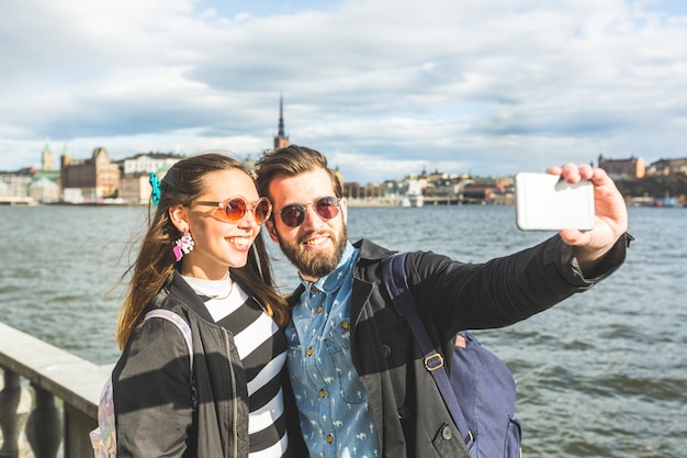 Pareja joven inconformista tomando un selfie en Estocolmo