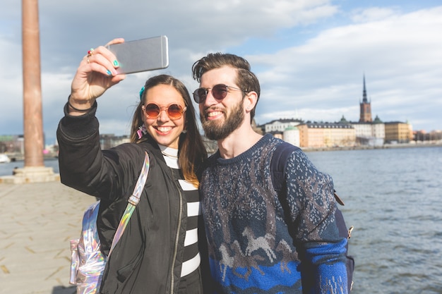 Pareja joven inconformista tomando un selfie en Estocolmo