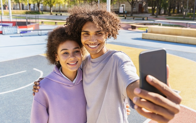 Pareja joven interracial que data al aire libre, color y fondo urbano moderno - Personas multiétnicas con ropa urbana elegante y fresca que se unen al aire libre