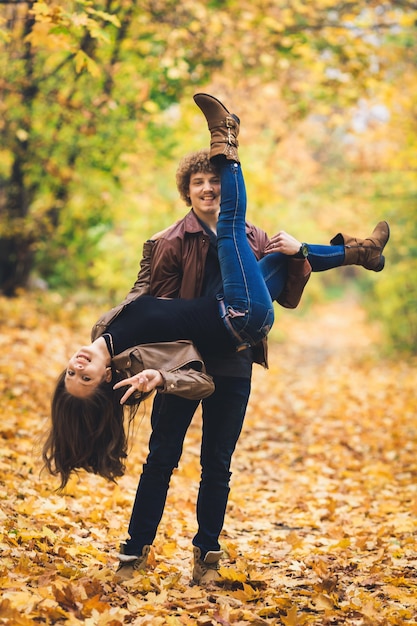 Pareja joven jugando en el parque otoño